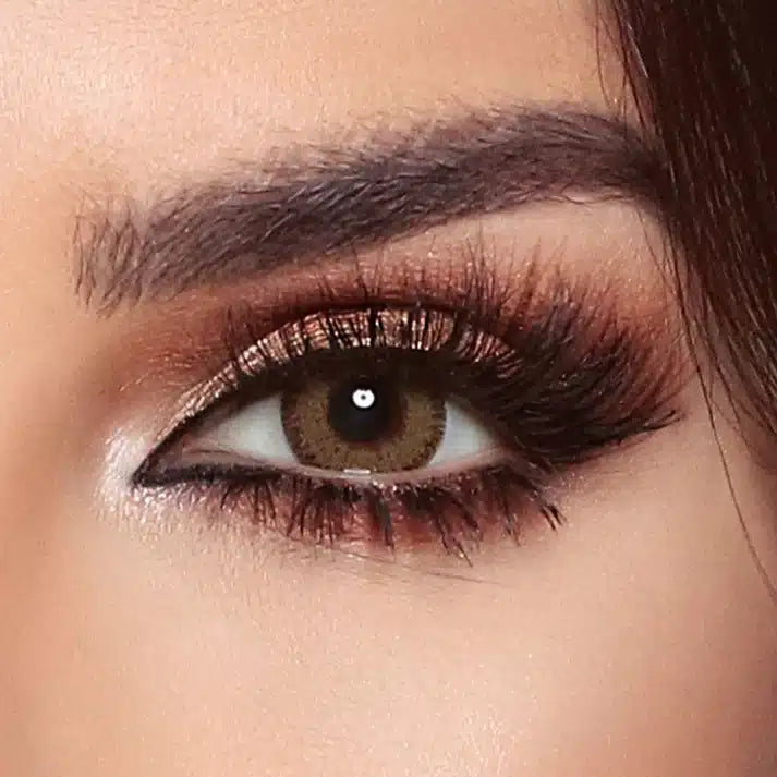 Close-up of a woman's eye with makeup, including eyeliner and mascara. Bella Glow Glow Radiant Hazelnut.