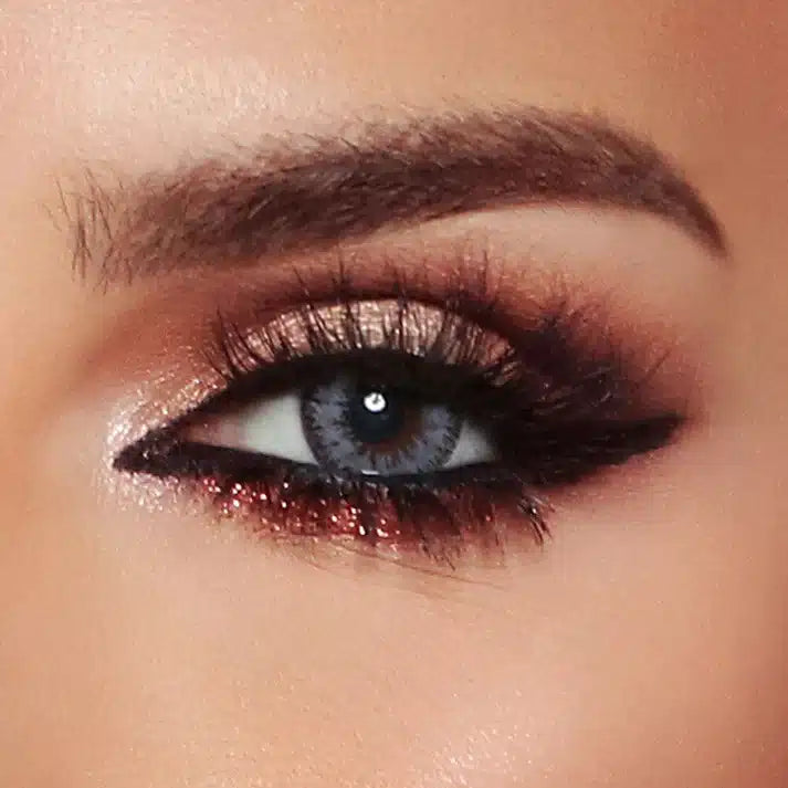 Close-up of a person's eye with dramatic makeup. Bella Glow Radiant Grey.