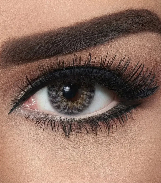 Close-up of a woman's eye with makeup, including eyeliner and mascara. Bella Natural Grey