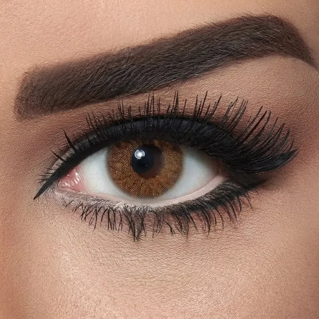 Close-up of a brown eye with detailed makeup on a neutral background. Bella Natural Hazel.