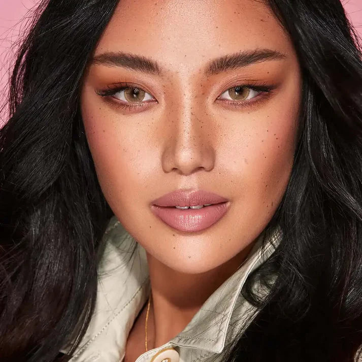 Close-up of a person with dark hair and makeup, wearing a light-colored shirt. Bella One Day Hazel Beige