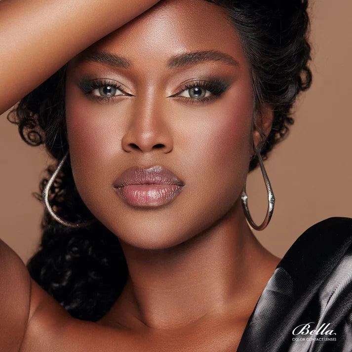 Woman with hoop earrings and a black garment on a beige background. Bella One Day Pine 3